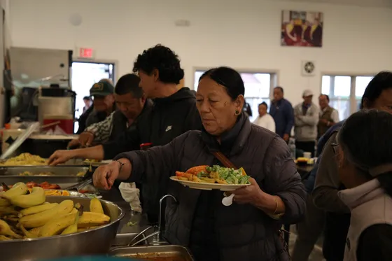 Elder woman at food service line receiving a meal