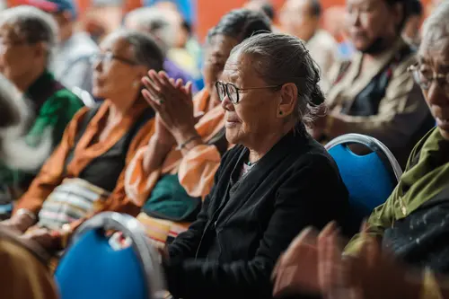 Elder woman in prayer during a community gathering