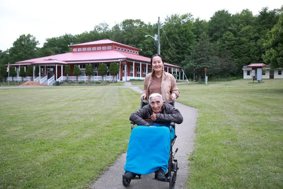 Caregiver assisting an elder in a wheelchair at a retreat