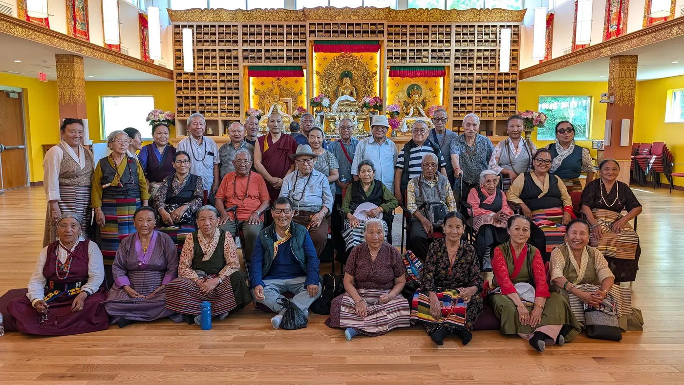 Large group photo of Himalayan elders at a Buddhist temple