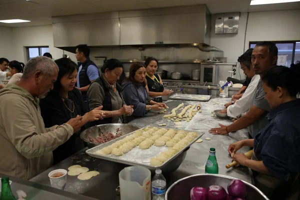 Community members making momos together in the kitchen