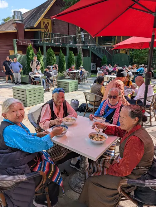 Elders enjoying a meal outdoors at Woodstock outing